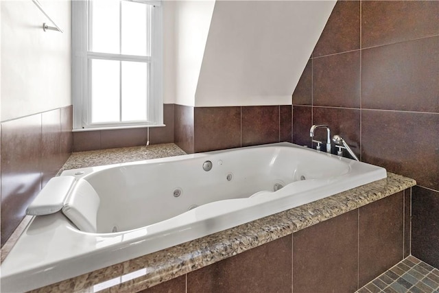 full bathroom featuring tile walls and a whirlpool tub