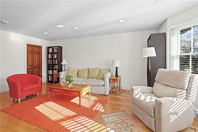 living area featuring recessed lighting, baseboards, and light wood finished floors