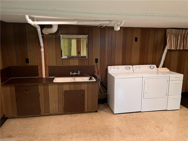 washroom featuring light floors, laundry area, a sink, and washing machine and clothes dryer