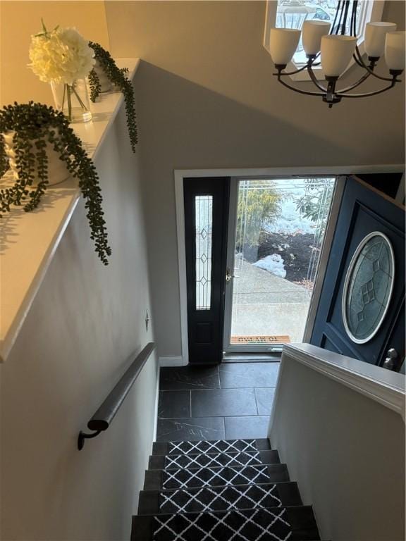 entryway with lofted ceiling and a chandelier