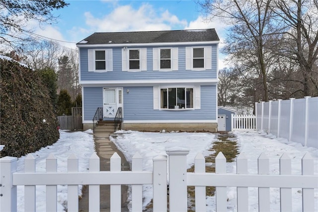 colonial house with a fenced front yard and a gate