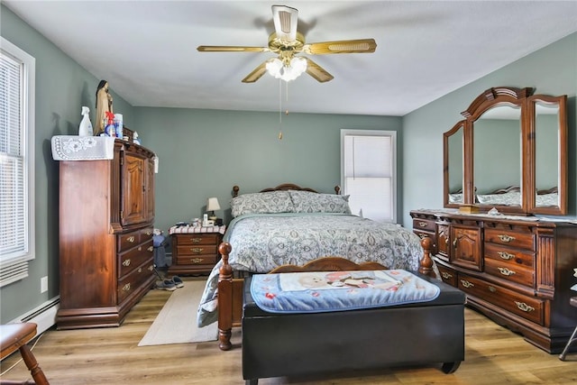 bedroom with light wood-type flooring, ceiling fan, and multiple windows