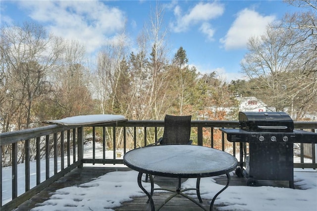 snow covered deck with a grill