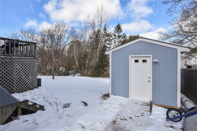 yard covered in snow featuring a storage shed and an outbuilding