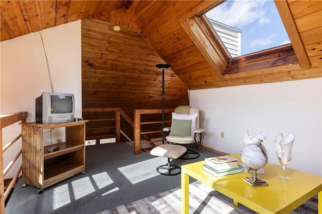 sitting room with vaulted ceiling with skylight, wooden ceiling, wood walls, an upstairs landing, and carpet