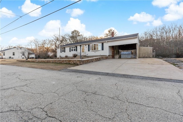 view of front of house featuring driveway, a garage, and a chimney