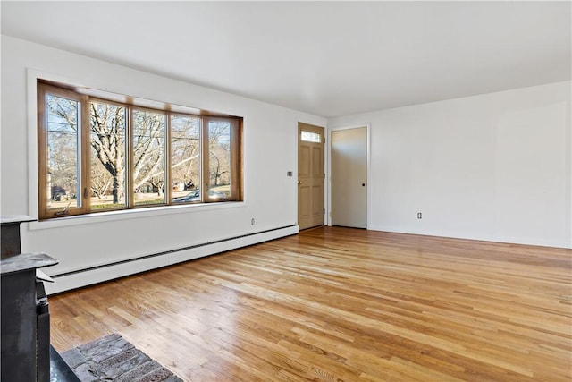 unfurnished room with a baseboard radiator and light wood-style flooring