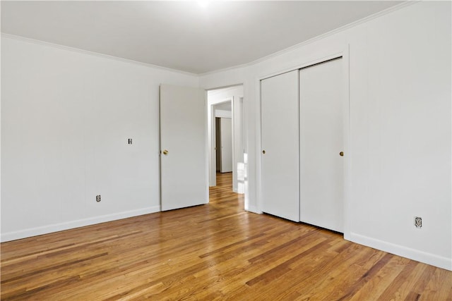 unfurnished bedroom with light wood-style floors, crown molding, and baseboards