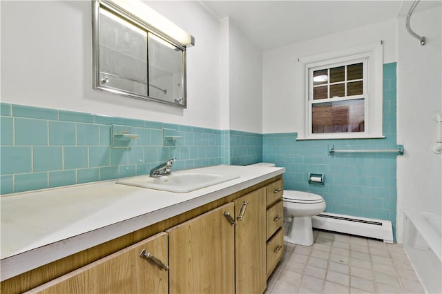 full bath featuring toilet, a wainscoted wall, a baseboard radiator, vanity, and tile walls