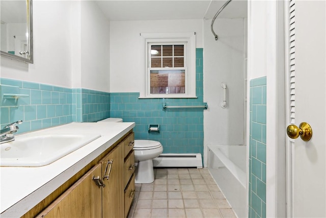 full bathroom with tile walls, toilet, a baseboard heating unit, wainscoting, and vanity