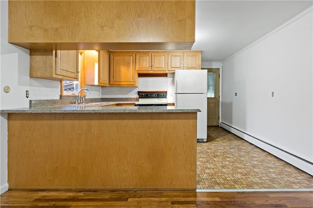 kitchen featuring baseboard heating, freestanding refrigerator, a sink, range, and a peninsula