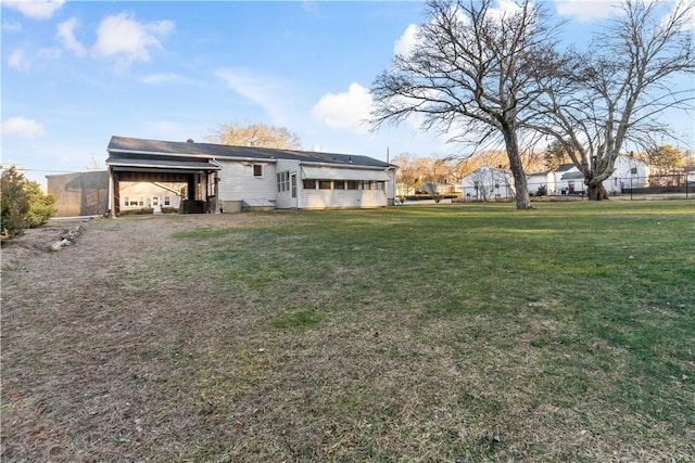 rear view of house with a yard and fence