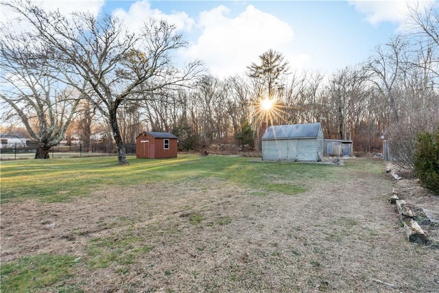 view of yard with an outdoor structure, a storage shed, and fence