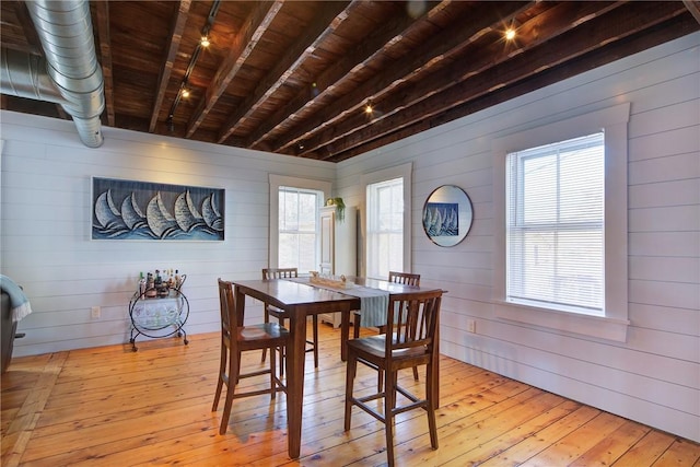 dining area featuring light wood-type flooring, beamed ceiling, and wooden ceiling