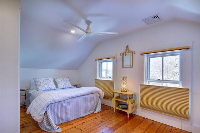 bedroom featuring lofted ceiling, visible vents, and wood-type flooring