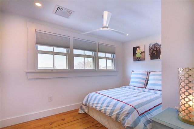 bedroom featuring a ceiling fan, wood finished floors, visible vents, baseboards, and recessed lighting