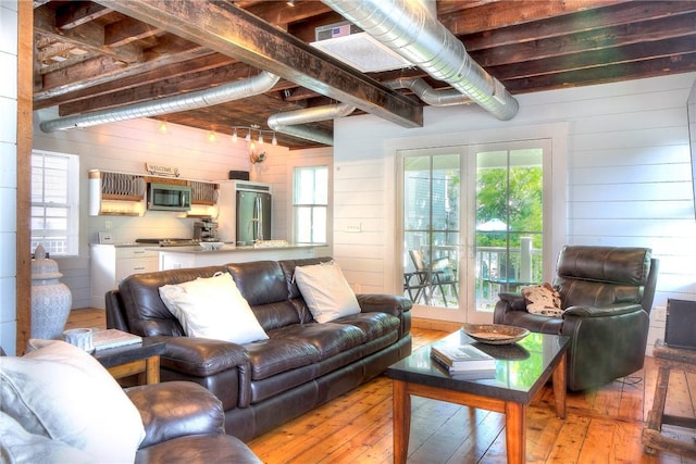 living room with light wood finished floors and wooden walls