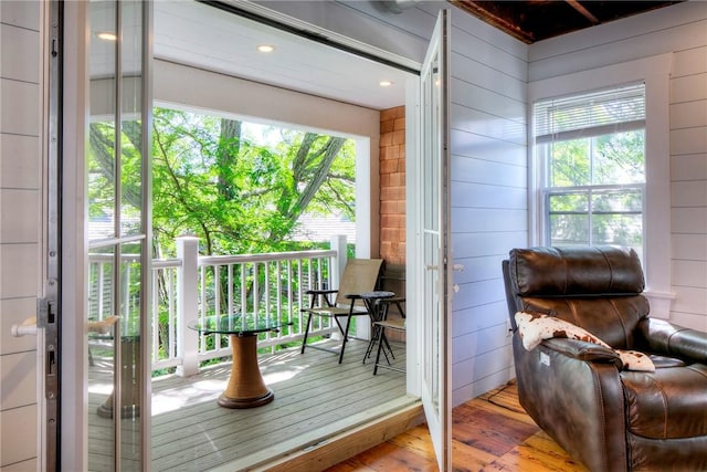 doorway to outside featuring wooden walls and wood finished floors