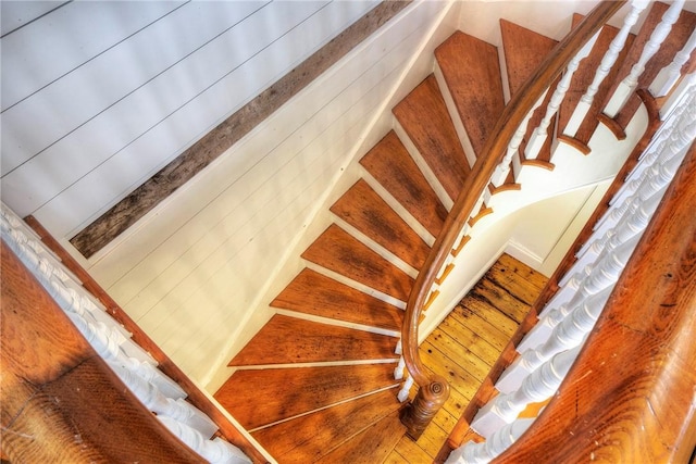 staircase featuring wood walls