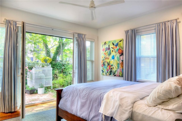 bedroom featuring multiple windows, ceiling fan, and access to outside