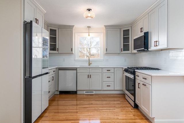 kitchen featuring appliances with stainless steel finishes, visible vents, a sink, and backsplash