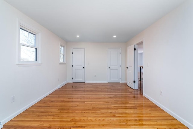 empty room featuring light wood-style flooring, baseboards, and recessed lighting