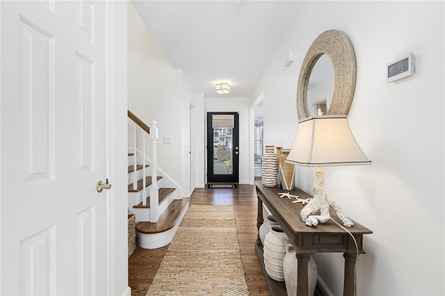 foyer entrance featuring stairway, wood finished floors, and baseboards