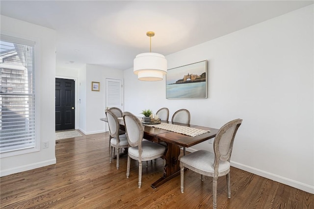 dining space with baseboards and wood finished floors