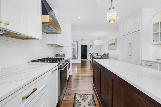 kitchen with white cabinets, glass insert cabinets, stainless steel gas range, range hood, and backsplash