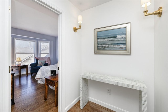 corridor with baseboards and wood finished floors