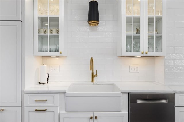 bar featuring dishwasher, backsplash, and a sink