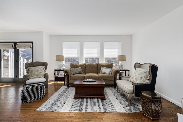 living area with baseboards and wood finished floors