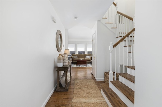 hall with stairs, baseboards, and wood finished floors