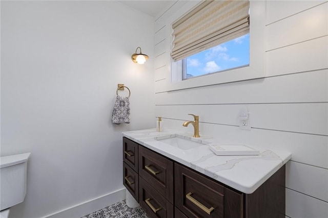 bathroom with baseboards, vanity, and toilet