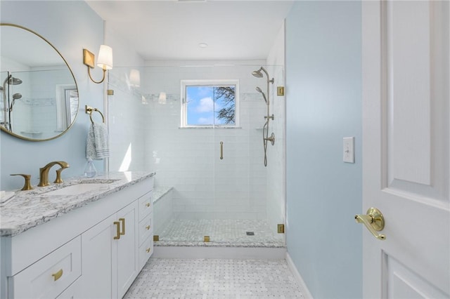 full bathroom with a shower stall, vanity, and baseboards