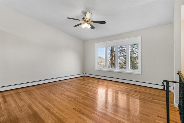 empty room featuring ceiling fan, a baseboard heating unit, and wood finished floors