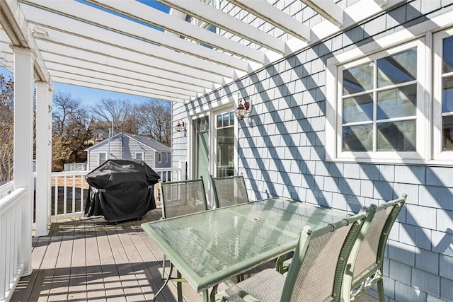 deck featuring a grill, outdoor dining area, and a pergola