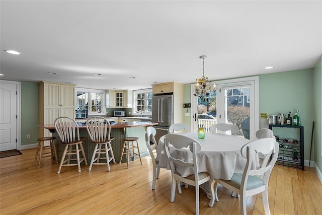 dining room with light wood-style floors, recessed lighting, baseboards, and an inviting chandelier