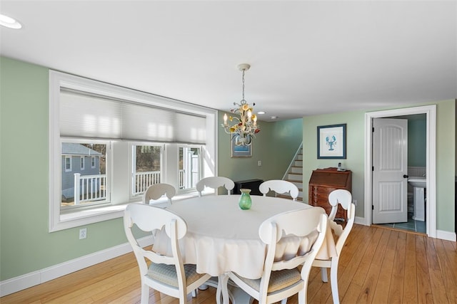 dining area with an inviting chandelier, baseboards, stairway, and hardwood / wood-style floors