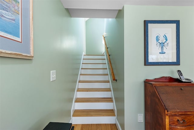 stairway with wood finished floors and baseboards