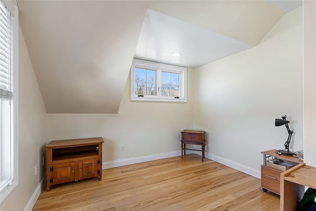 interior space with lofted ceiling, light wood finished floors, and baseboards