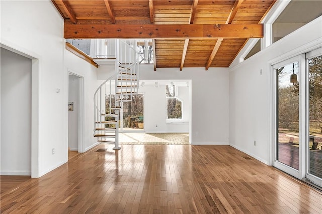 unfurnished living room with vaulted ceiling with beams, stairway, wood ceiling, baseboards, and hardwood / wood-style flooring