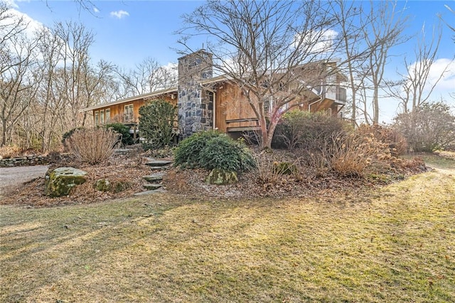 exterior space with stone siding and a chimney