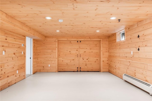 unfurnished room featuring recessed lighting, concrete floors, wooden walls, and baseboard heating