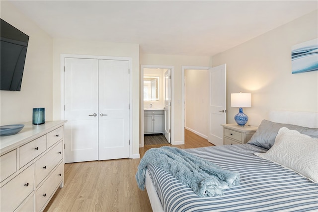 bedroom with a closet, ensuite bathroom, and light wood-style floors