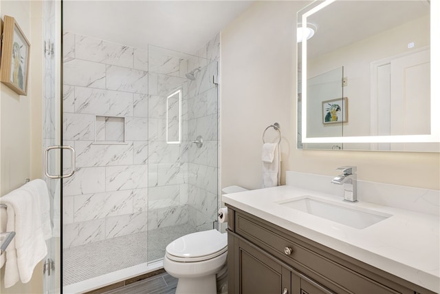 full bath featuring a shower stall, toilet, vanity, and wood finished floors