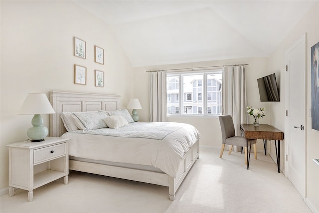 bedroom with light colored carpet, baseboards, and lofted ceiling