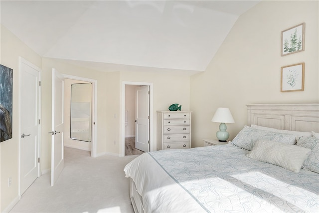 bedroom featuring lofted ceiling, light colored carpet, and baseboards