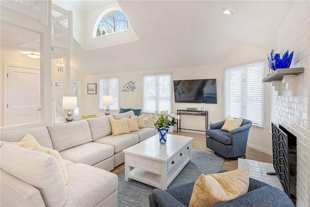 living room with lofted ceiling, a brick fireplace, recessed lighting, and wood finished floors