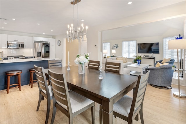 dining room with recessed lighting, light wood-type flooring, and a chandelier